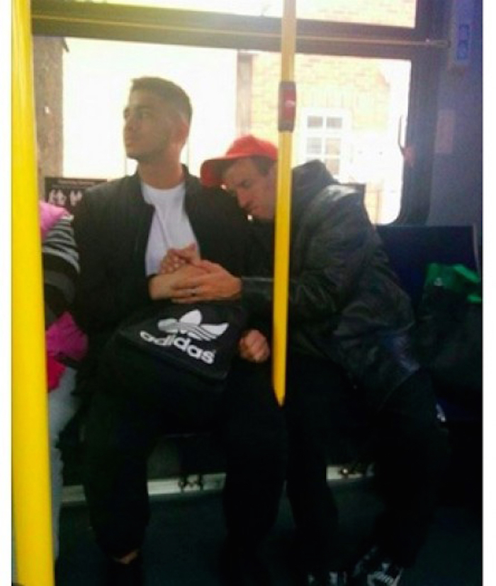 man holds strangers hand on bus main